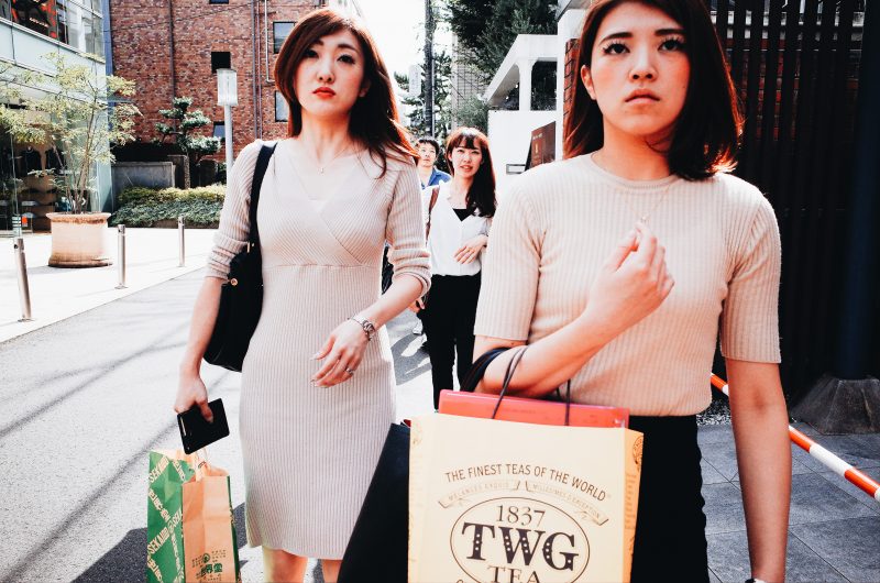Girls with shopping bags walking towards me. I use the 'cutoff technique' to get in front of them, and to shoot head-on, to make a more dynamic street photography composition. Tokyo, 2017