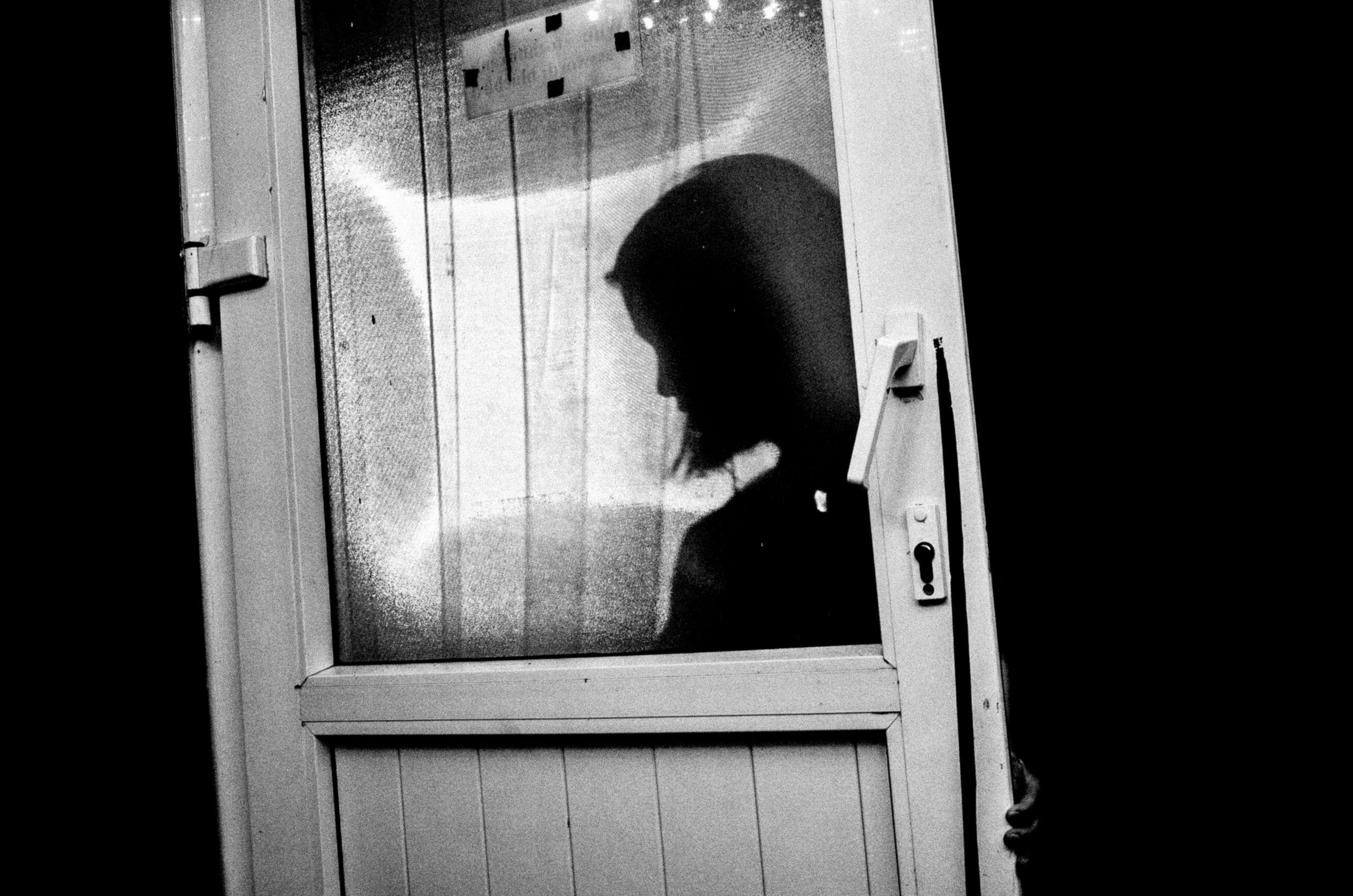 Silhouette of woman behind door. Hanoi, 2017