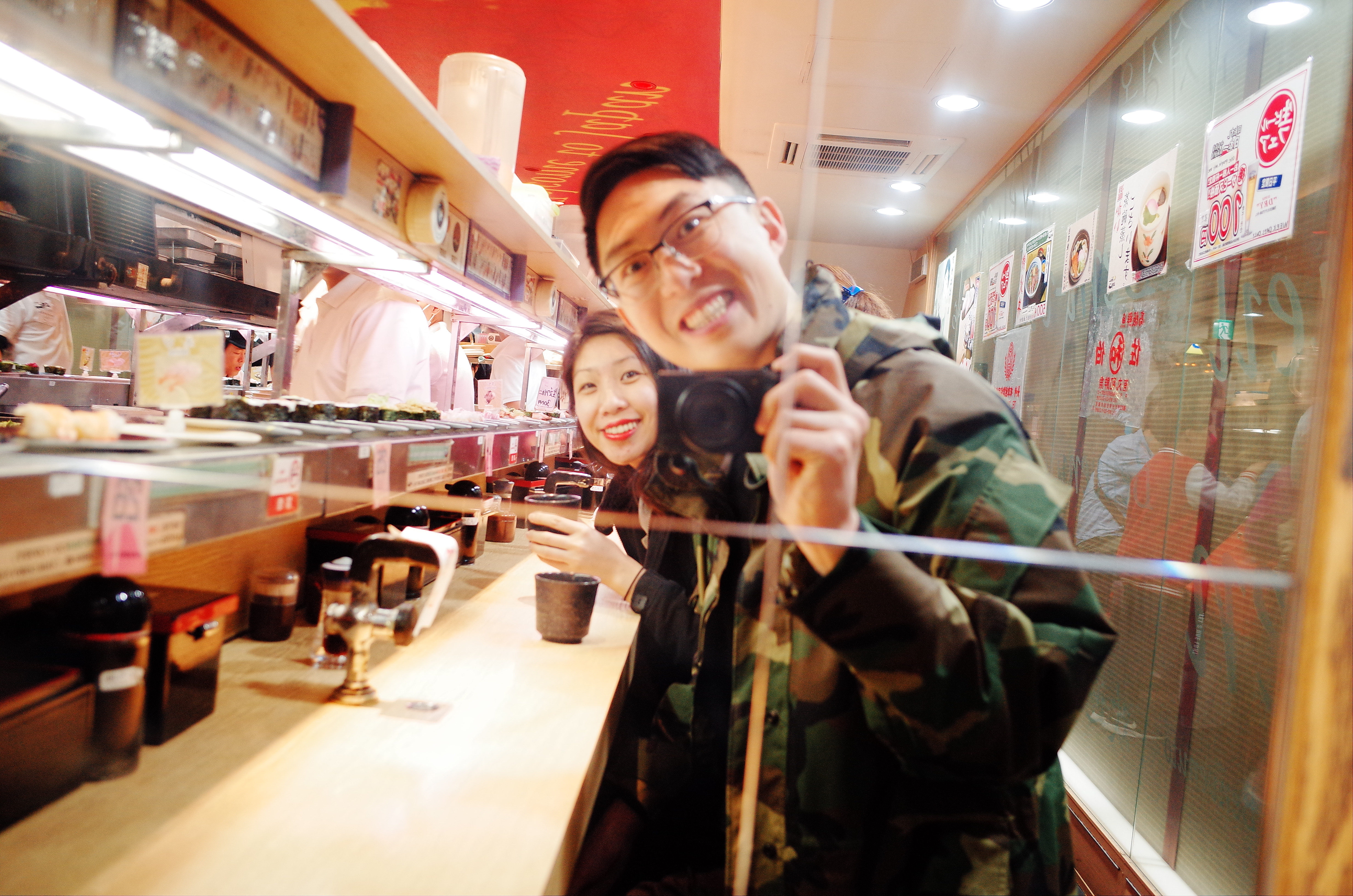 Selfie in the mirror with Cindy at conveyer belt sushi. Osaka, 2018