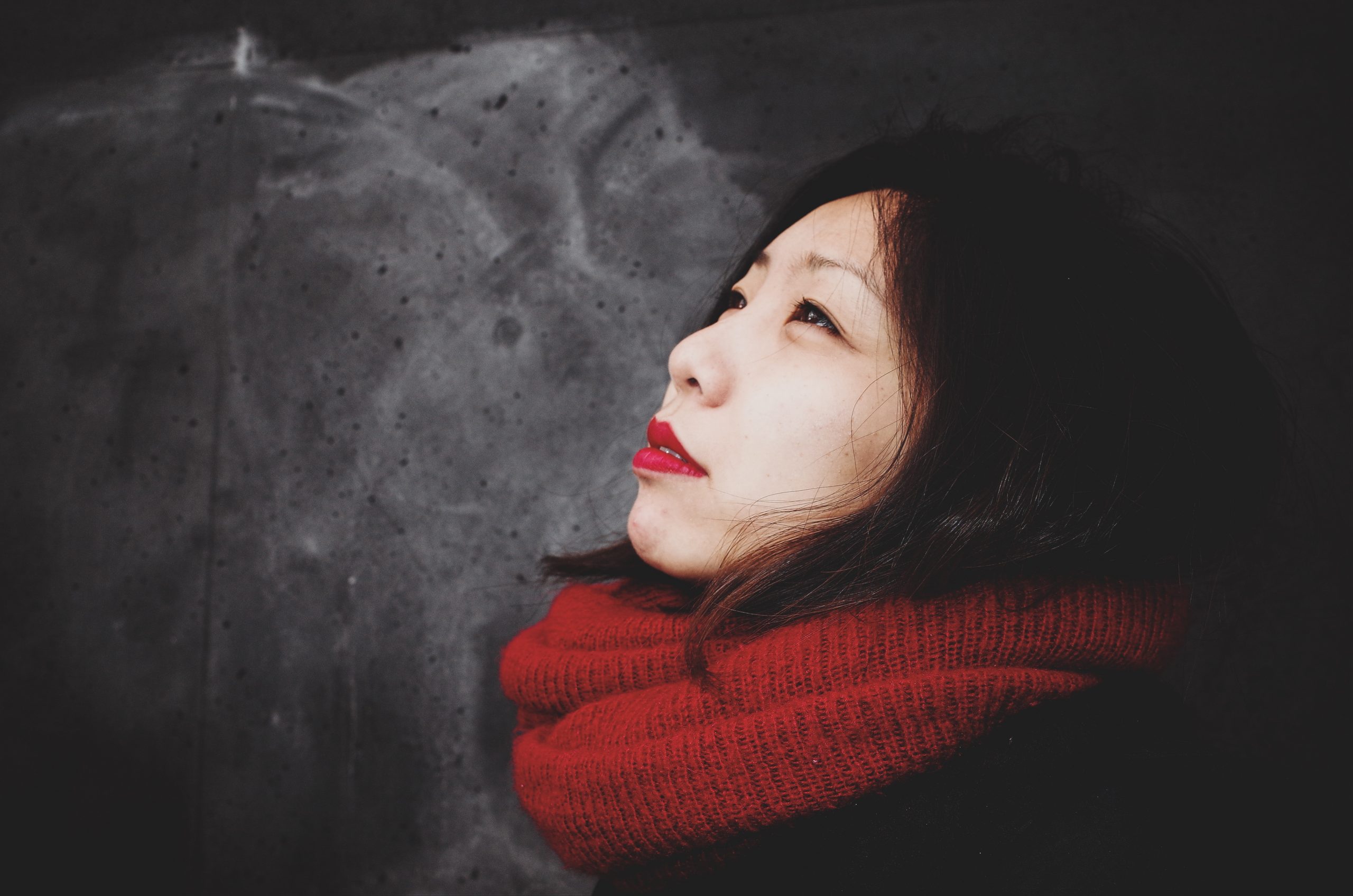 Cindy wearing a red scarf with red lipstick against grey and white wall in Berlin germany