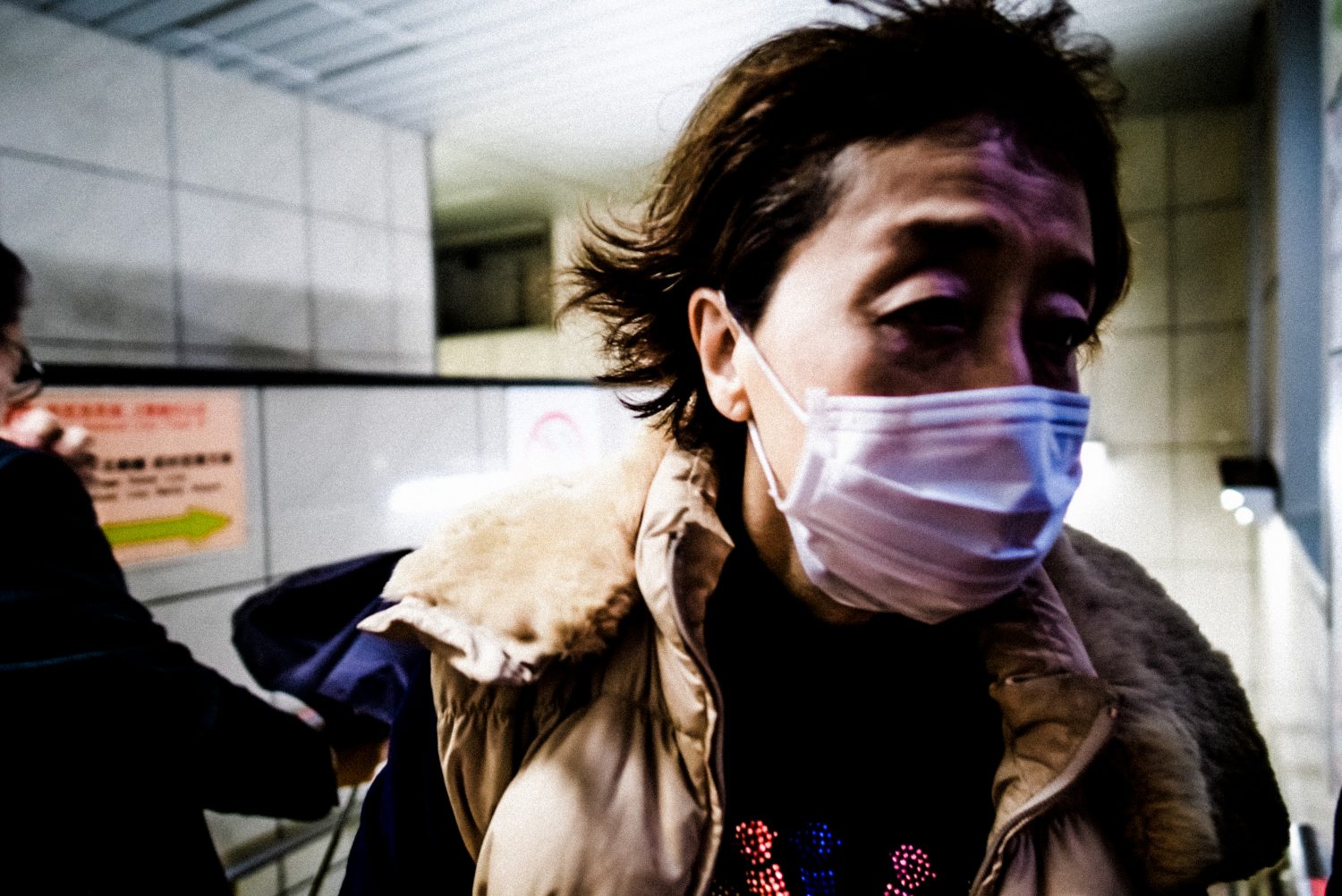 Woman with face mask in Tokyo subway. 2018