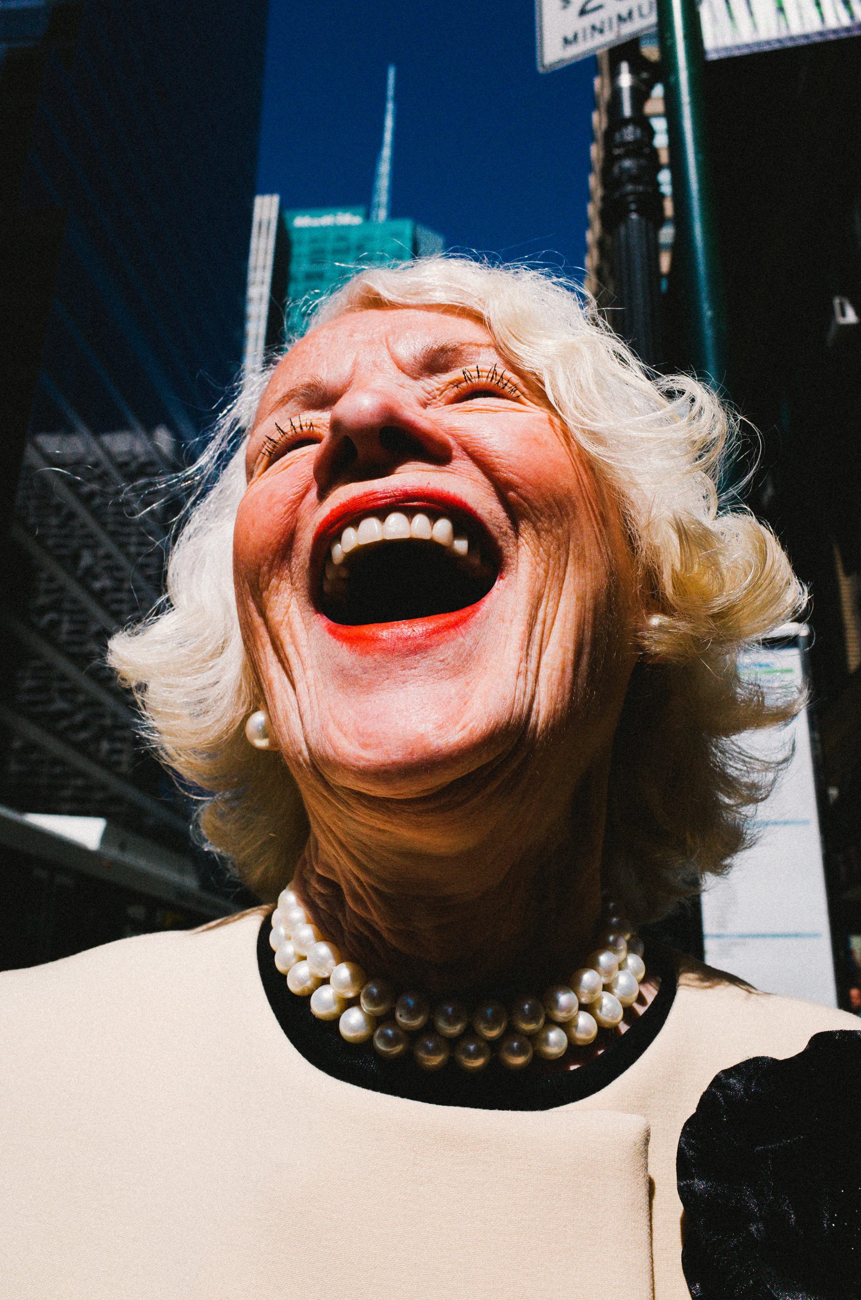 ERIC KIM laughing lady white hair red lips blue sky New York City street portrait Ricoh gr ii macro mode 28mm