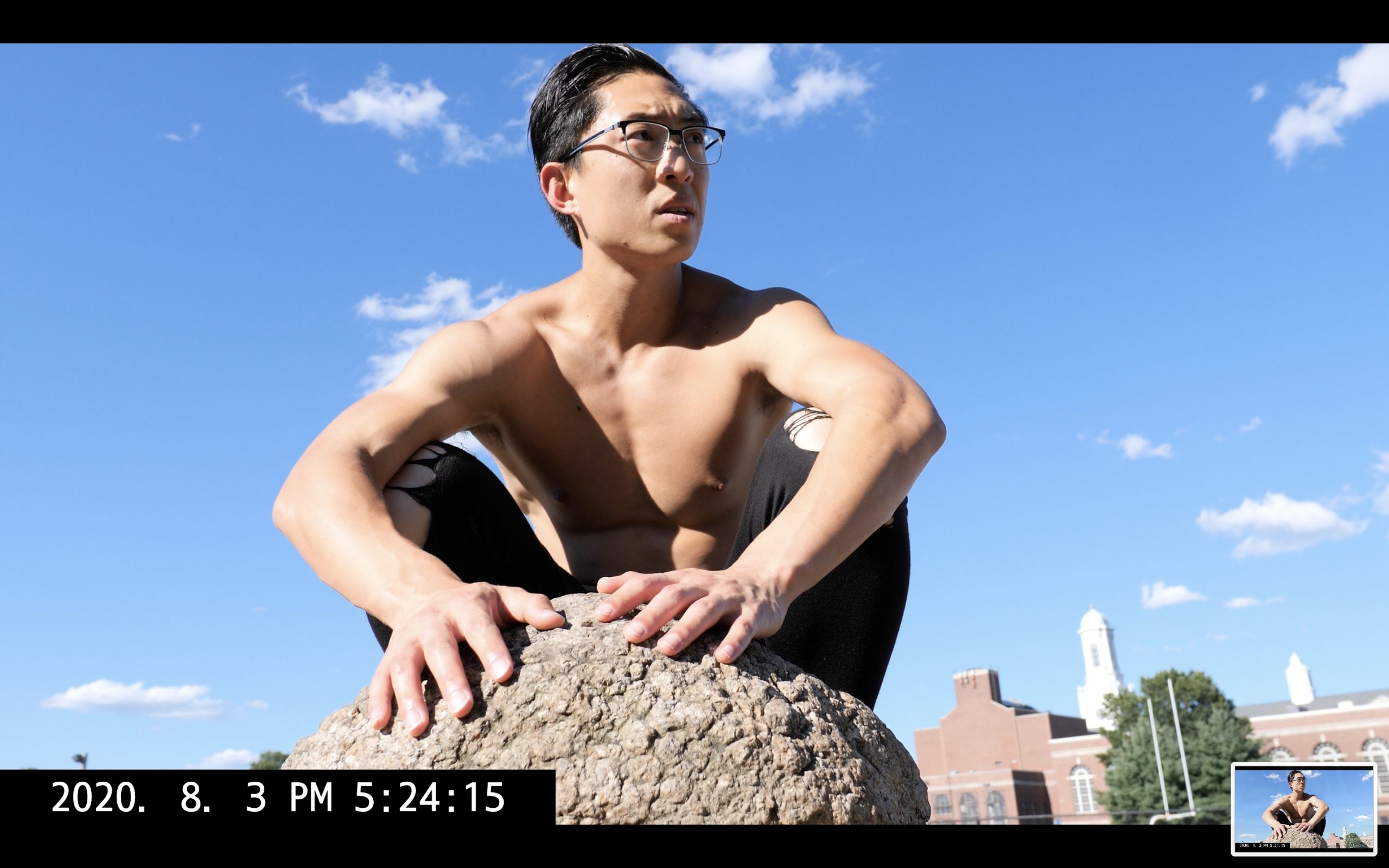 selfie ERIC KIM crouching with a rock looking into the distance